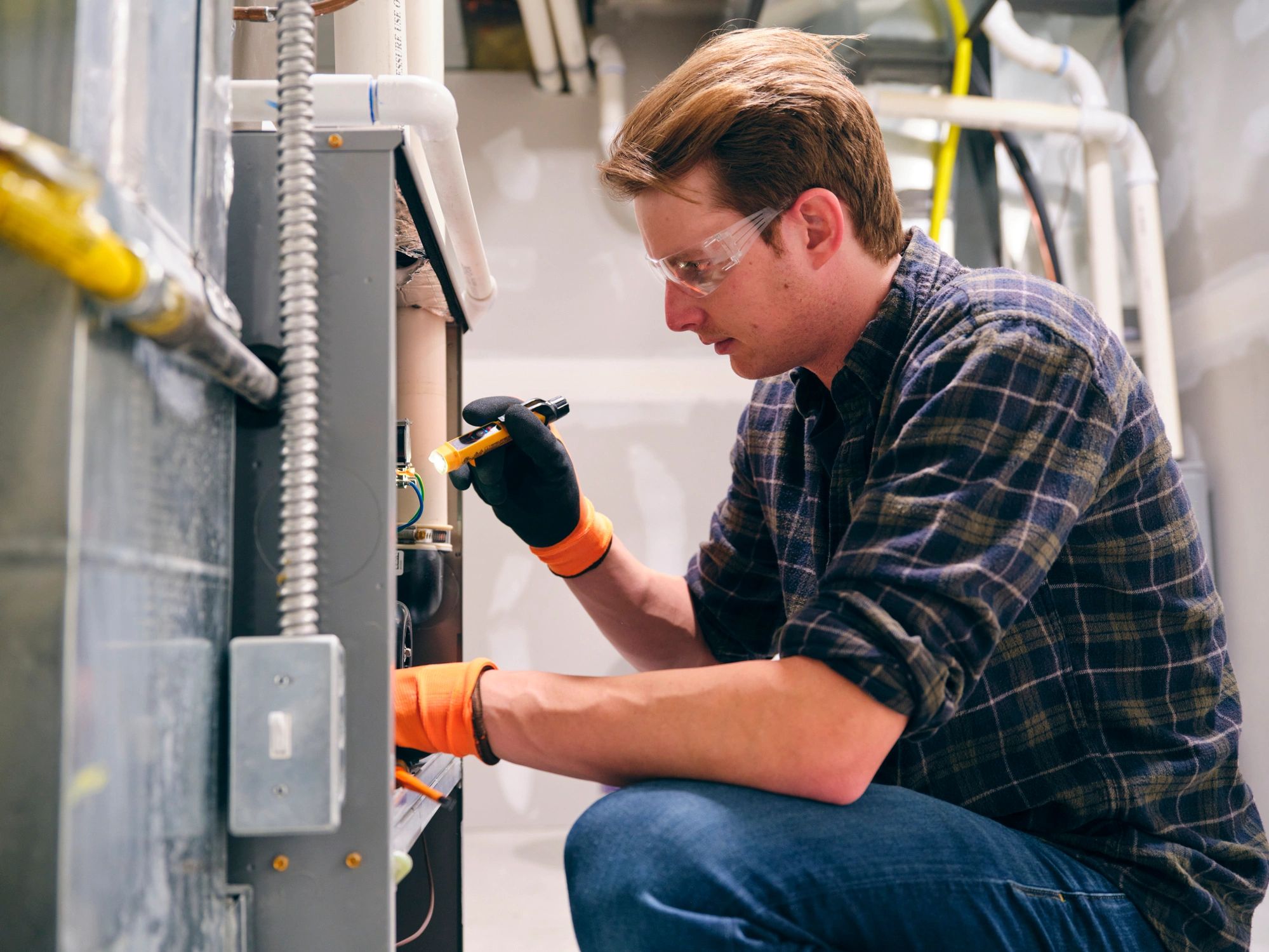 Repairman working on a home furnace for maintenance