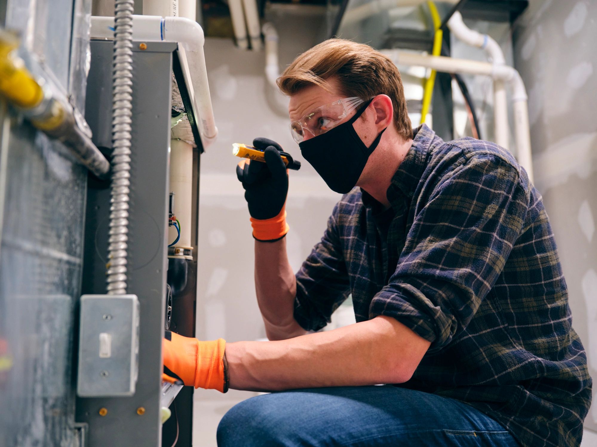 Technician performing home maintenance with protective mask