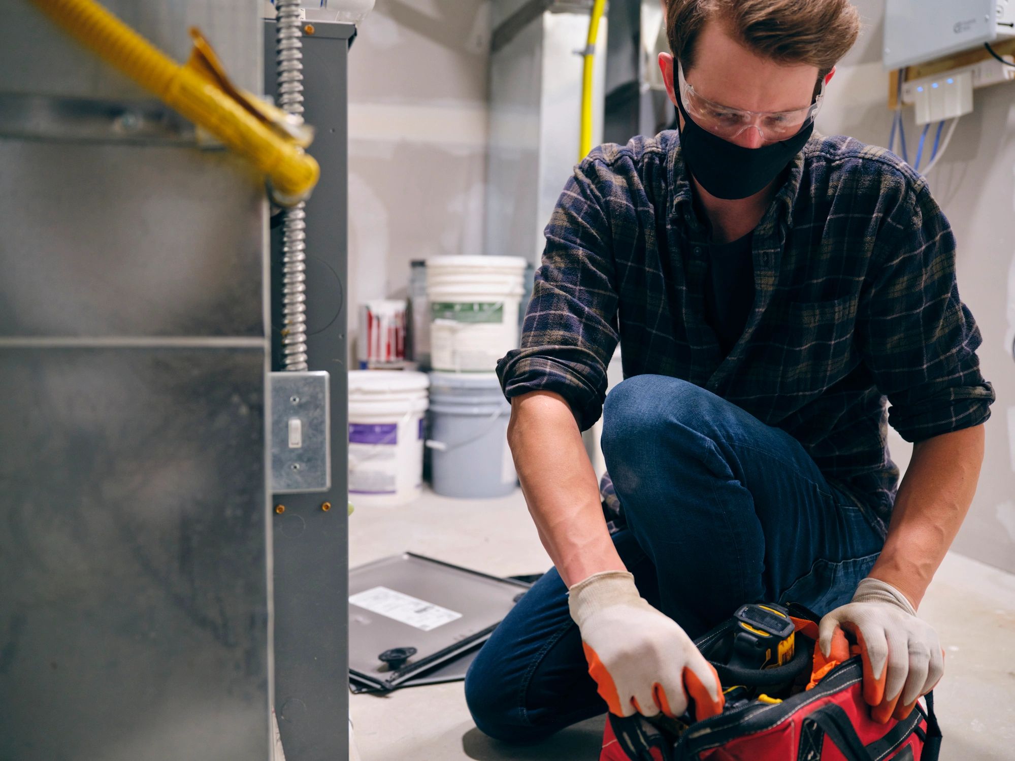 Technician performing AC duct cleaning service in a home